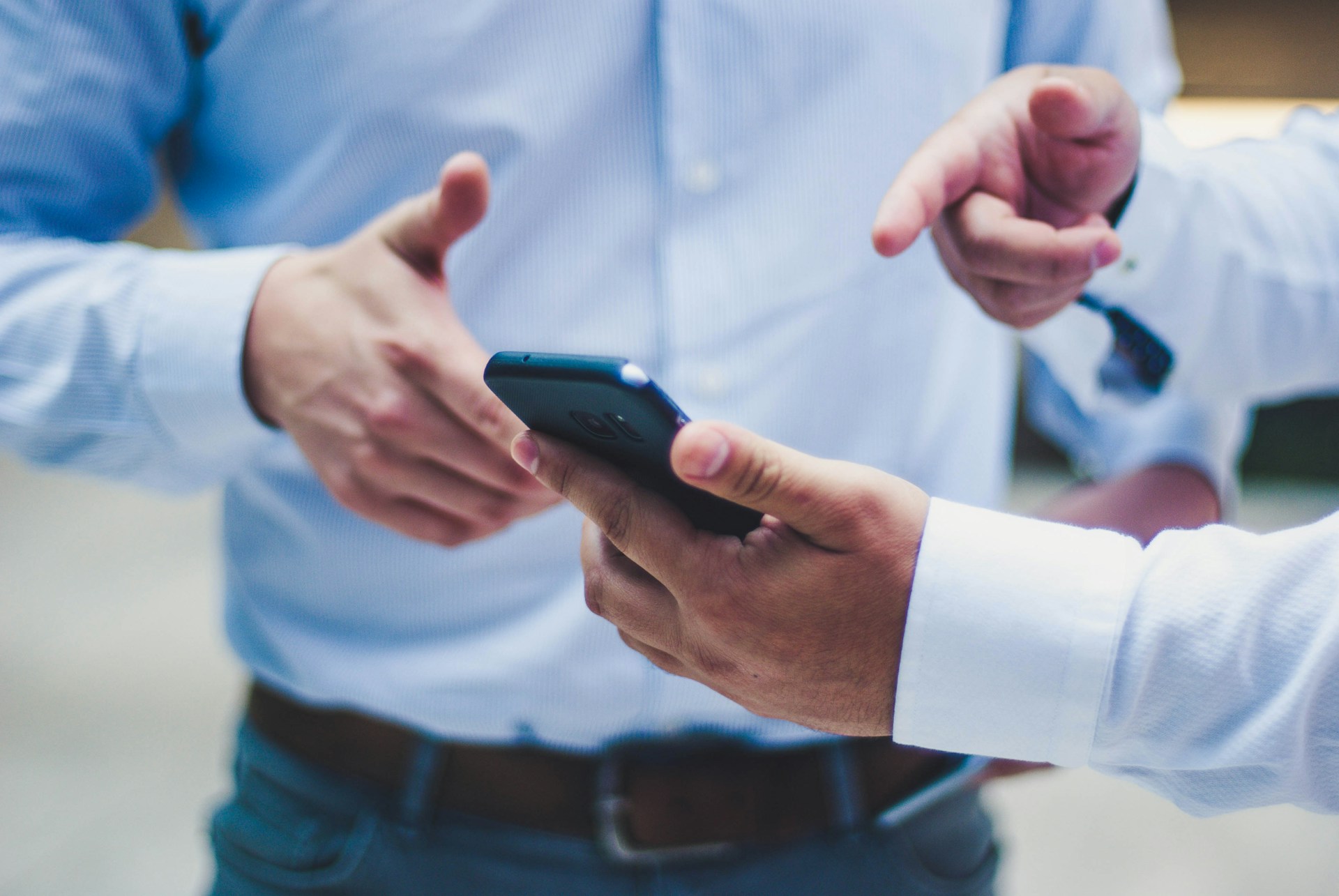 Two people in shirts discussing something on a smartphone