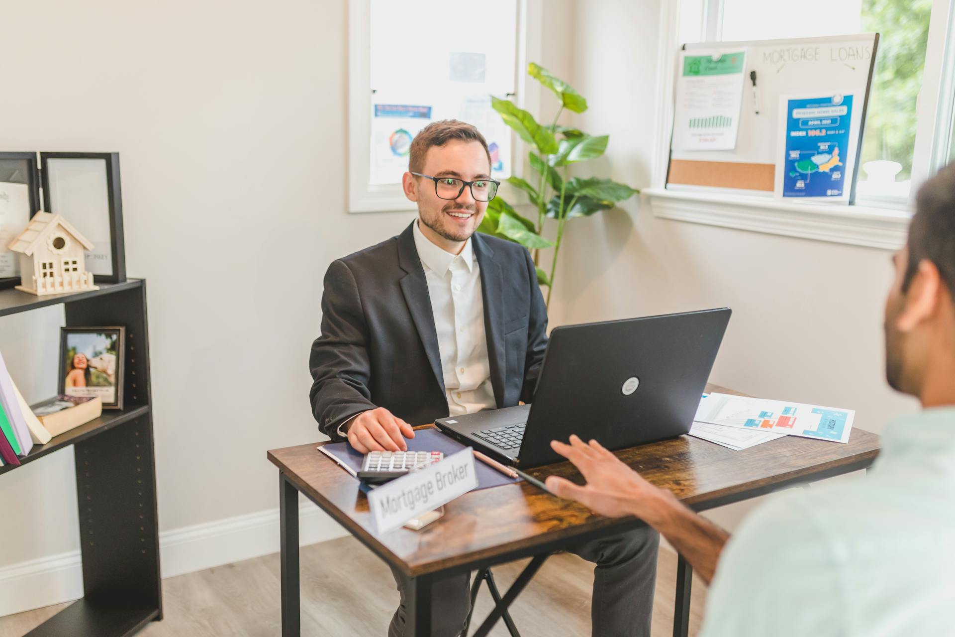Mortgage broker at his desk talking with a client